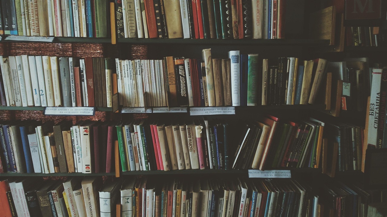 Kleurrijke boekenwand in minimalistische leeshoek. Kleurrijke boekenwand in minimalistische leeshoek.