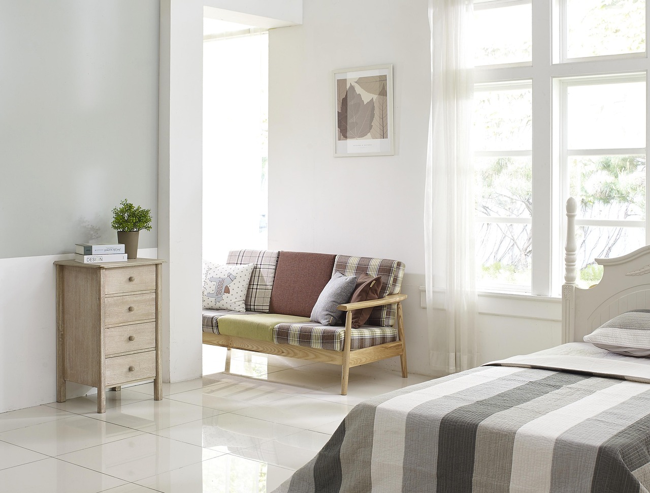 Zachte pastel beddengoed met sfeerlicht.