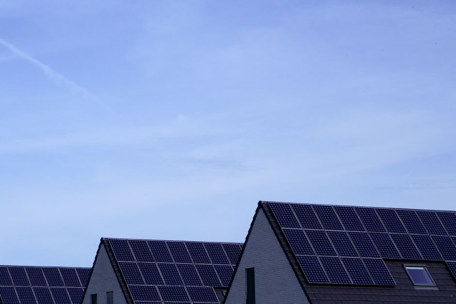Huis met zowel zonnepanelen als windturbine.