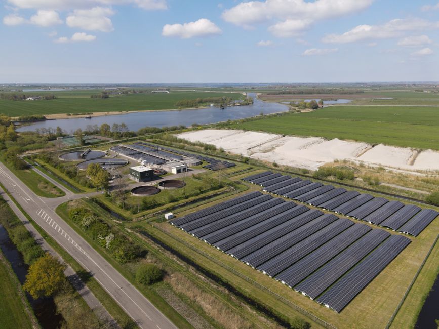 Zonnepanelen op een dak bij zonsondergang.