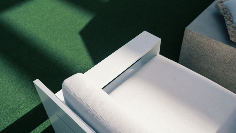 Duurzame rotan loungestoel met groene kussens.