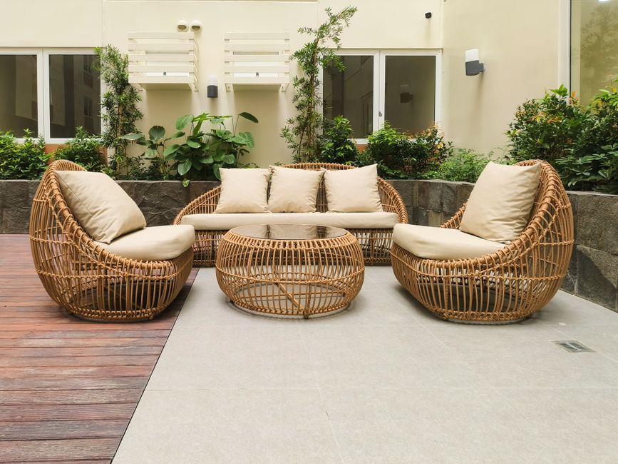 Luxe rotan loungebank in zonnige buitenhoek. Luxe rotan loungebank in zonnige buitenhoek.